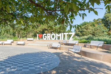Sitzgelegenheiten im Schatten nahe dem „I ♥ Grömitz“-Schriftzug, ideal für eine entspannte Pause an der Promenade.